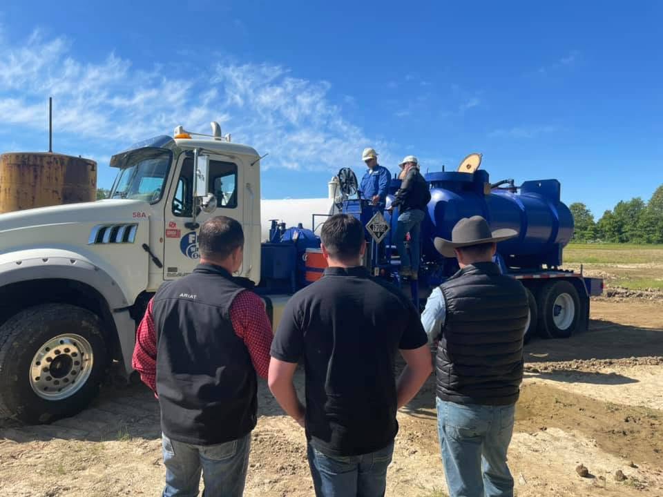 NEC Operating crew meeting beside a vacuum truck on location